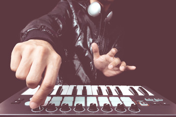 professional musician or DJ hands playing studio keyboard synthesizer for dance , groove, remix, underground music background - obrazy, fototapety, plakaty