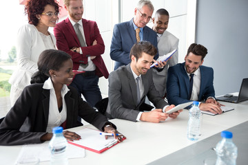 Business team read data from tablet at meeting