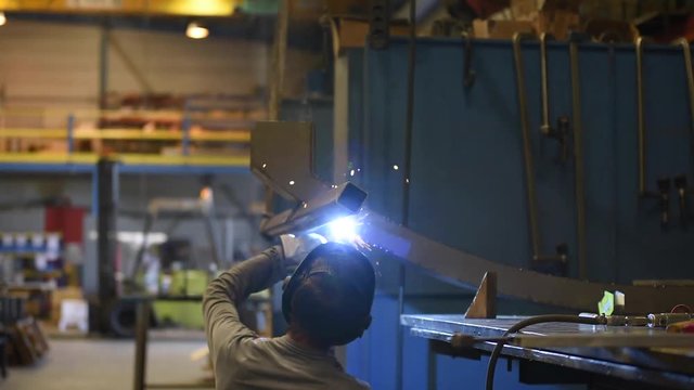 Metalworker welding in manufacture plant