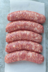 Raw sausages on wax papered gray background 