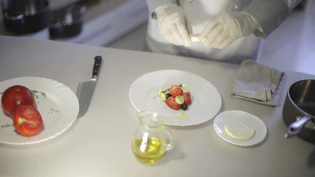 Chef prepares a Greek salad in the kitchen