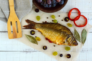 Baked fish carp, stuffed bell peppers and grapes. The top view.