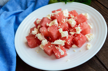 Light diet summer salad of fresh watermelon and feta cheese with sesame seeds.