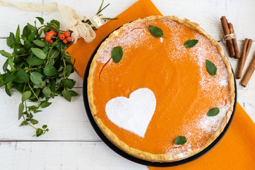 Sweet pumpkin pie on a white background. The top view. Dietary vegan dish. Traditional baked for Thanksgiving.