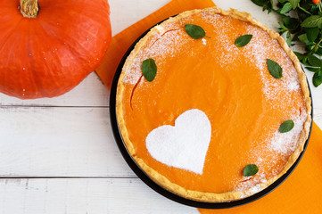 Sweet pumpkin pie on a white background. The top view. Dietary vegan dish. Traditional baked for Thanksgiving.