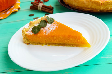 Sweet pumpkin pie. A piece on a white plate. Dietary vegan dish. Traditional baked for Thanksgiving.