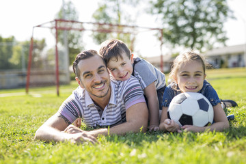 Fototapeta premium man with child playing football on field