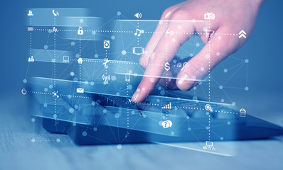 Hand pressing keyboard with high tech media icons