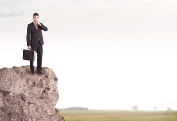 Happy salesman on cliff in the country