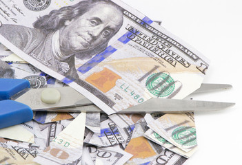 Scissors cut dollars on a white background
