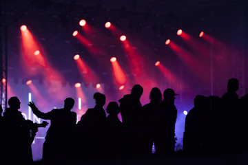 Fototapeta na wymiar Cheering crowd in front of stage lights