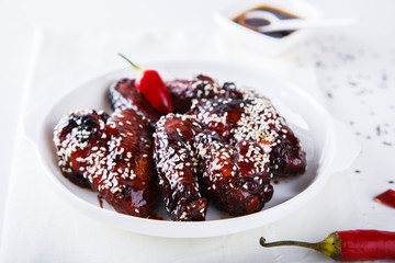 Chicken wings in soy sauce and sesame seeds, on a white background.selective focus.