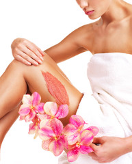 The woman with a beautiful with flowers body using a scrub