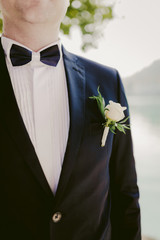 groom in black suit with boutonniere