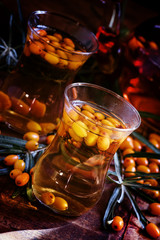 Curative tea with sea-buckthorn berries in oriental glasses, dar