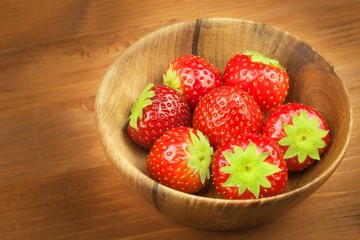 Strawberry on a wooden background. Strawberries in bowl.
