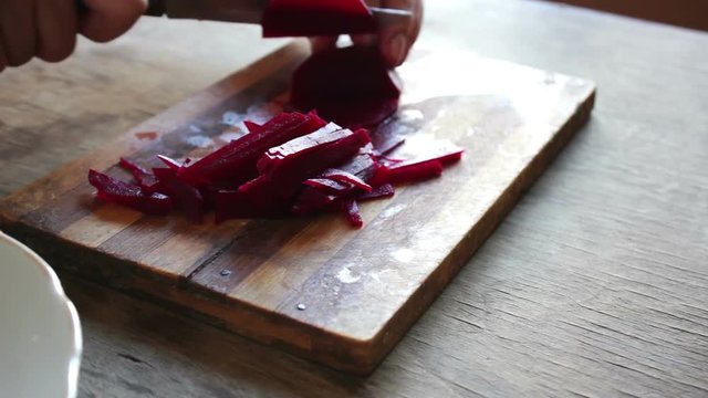 Cutting beet on a board chef cooking