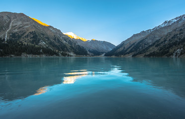 the water surface of a mountain lake, mountains reflected in the water, the water turquoise,summer
