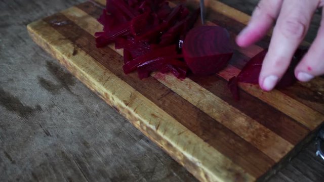 Cutting beet on a board chef cooking