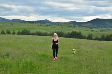 Fototapeta premium Woman hiking with her dog in mountain landscape in spring