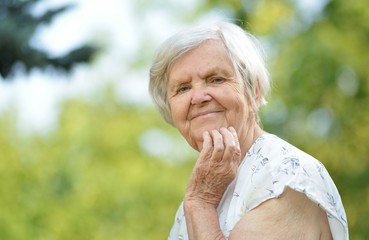 Senior woman smiling in park.