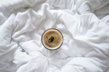 Cup of coffee on bed