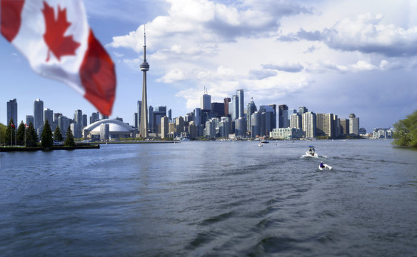 Beautiful Canada flag is waving front of famous Toronto City view