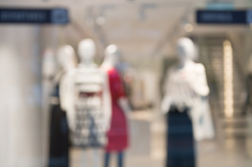 De focused/Blur image of boutique window with dressed mannequins. Boutique display window with mannequins in fashionable dresses. Toned image.