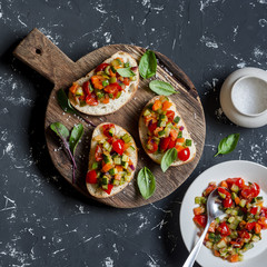 Sandwiches with quick ratatouille on rustic cutting board on a dark background. Delicious healthy vegetarian food. Top view