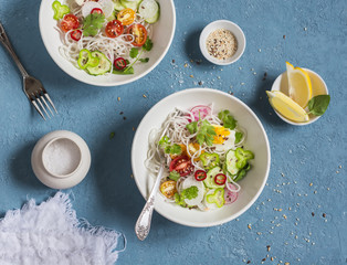 Rice noodles and vegetables salad. Healthy vegetarian food. On a blue background, top view