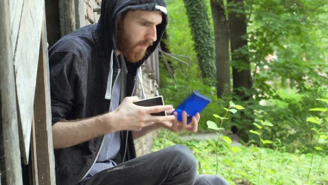 Nervous man sitting outside and calculate money from the wallet
