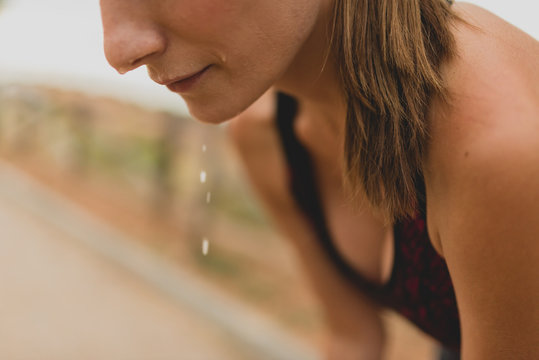 Close-up of waterdrop falling down from face of sportswoman