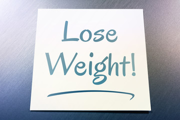 Lose Weight Reminder On Paper Lying On Brushed Aluminum Of Fridge