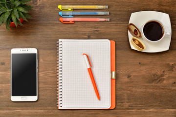 desk with laptop, smartphone and other supplies with cup of coffee. Blank notebook 