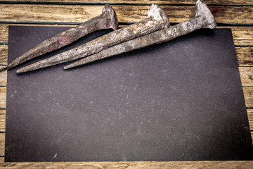 very old large nails on a beautiful wooden background, rusty