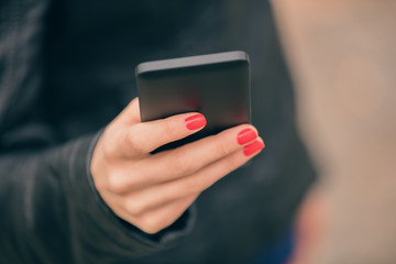 Urban girl using cellphone. Shallow depth of field.
