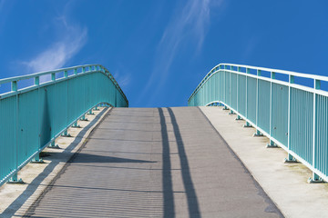 Fußgänger Brücke aus Stahl in Bogenkunstruktion über den Flu
