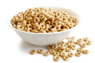 Bowl of honey cheerios isolated on white. Spilled cheerios.