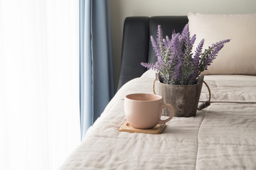 The bed with lavender flower and coffee cup in the morning.