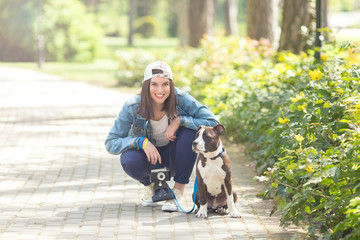 Happy teenage girl walking her dog in a park on a nice spring day