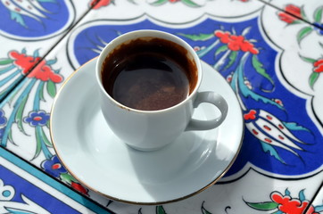 A cup of turkish coffee on a background of oriental tile 