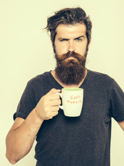 bearded serious man with cup of coffee or tea
