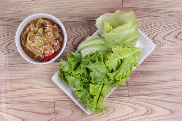Green chili dip " Nam Prik Num" served side dish as mixed fresh vegetable on red green. Top view