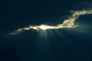 Fototapeta na wymiar Sun shines through clouds