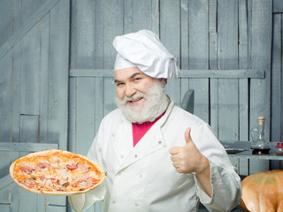 Bearded cook with pizza
