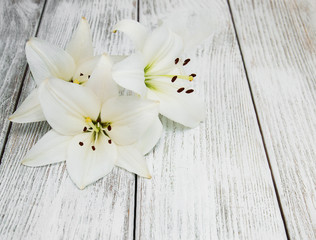 White  lilies on a wooden table