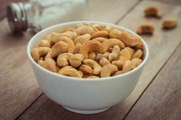 Cashew nuts in bowl and salt shaker, Filtered image