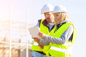 Two workers working outside on a construction site