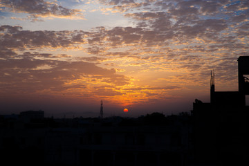 beautiful sunrise with colorful sky and clouds taken from a terrace with silhouette of buildings