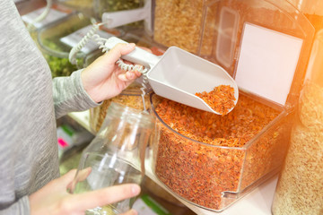 Young attractive woman shooping looses spices at the grocery